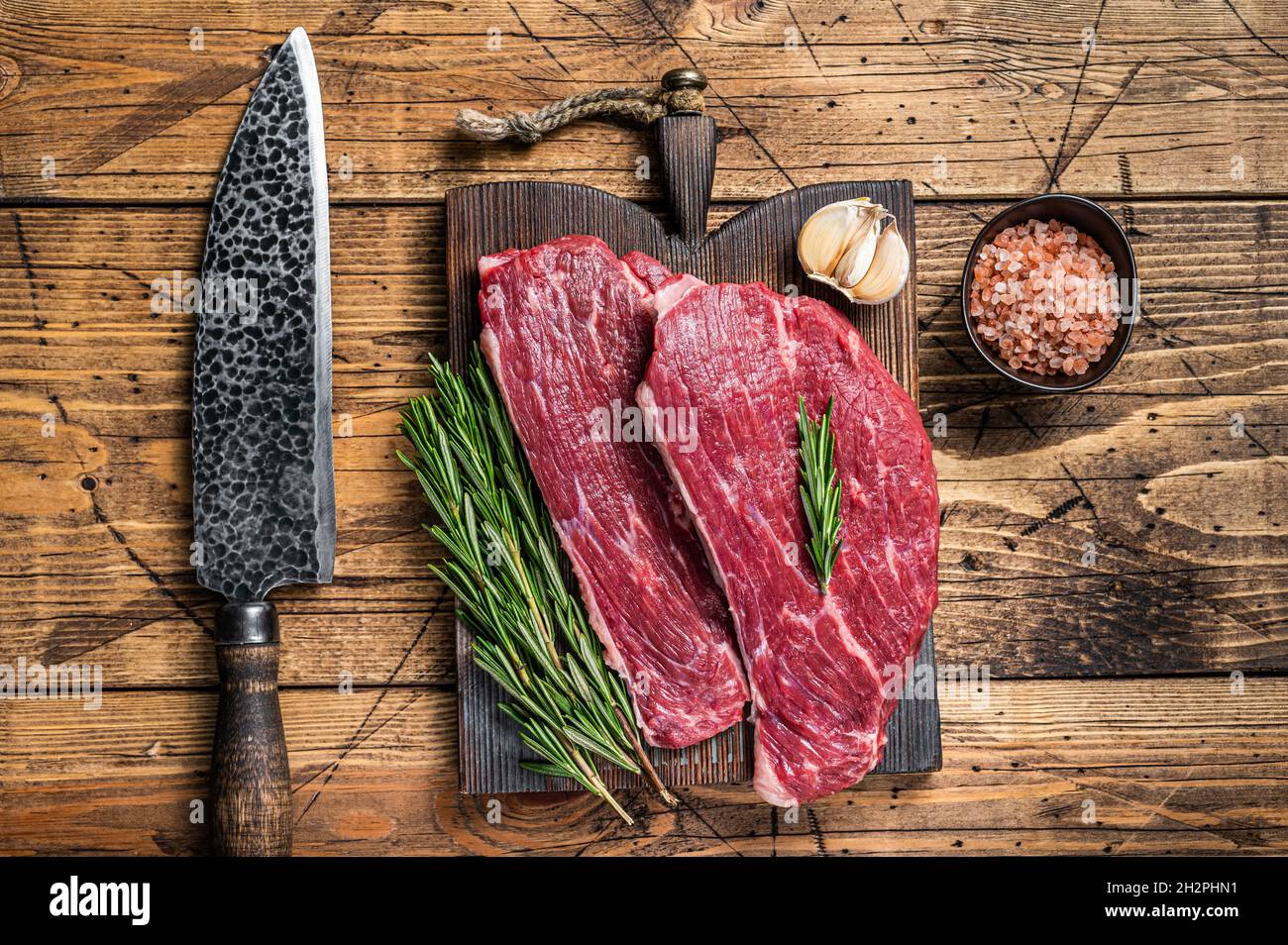 Steak de calotte cru ou steak de Picanha sur une planche de bois avec un couteau de boucher. fond en bois. Vue de dessus Banque D'Images