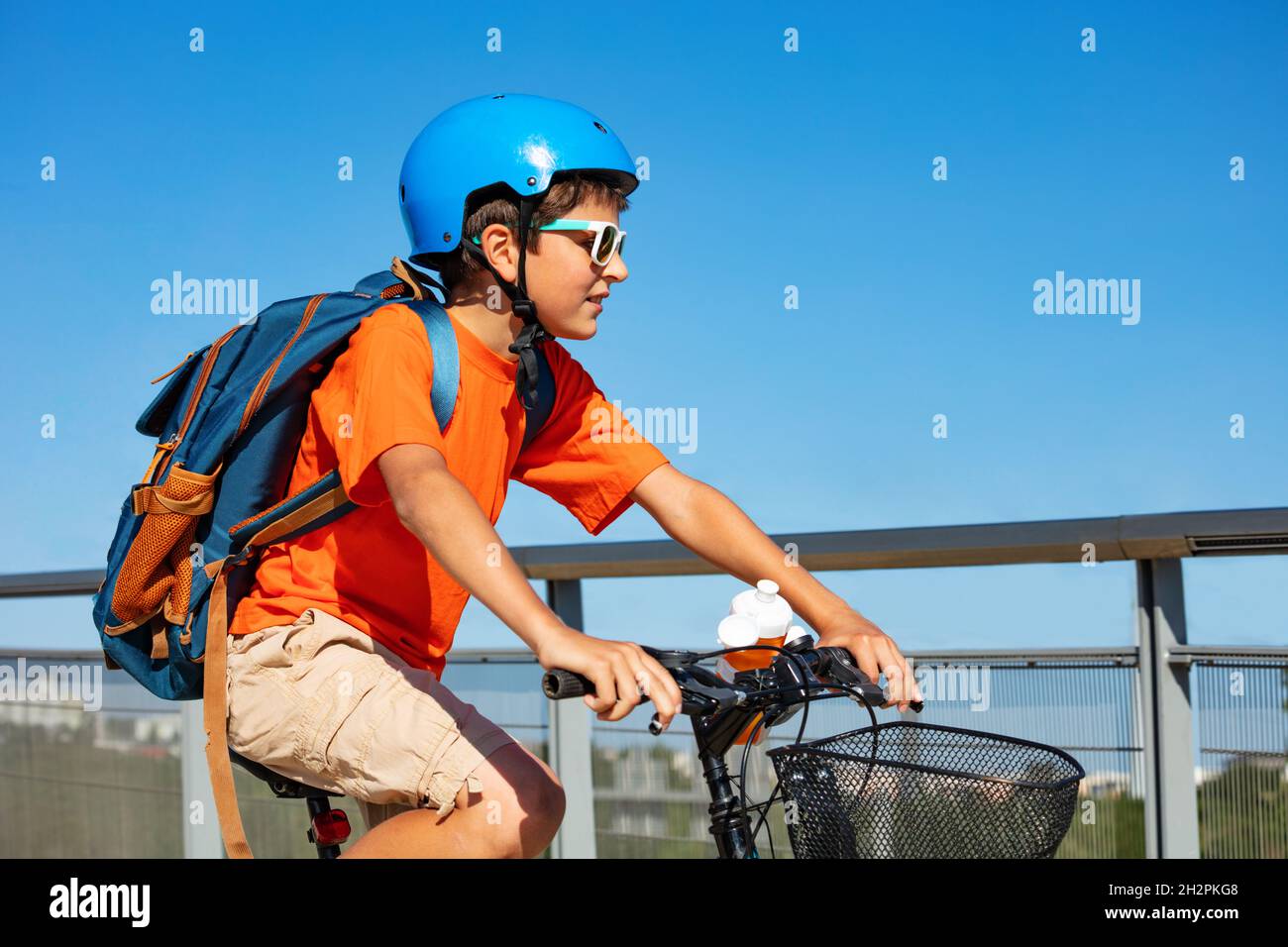 Portrait latéral d'un garçon avec sac à dos sur vélo Banque D'Images