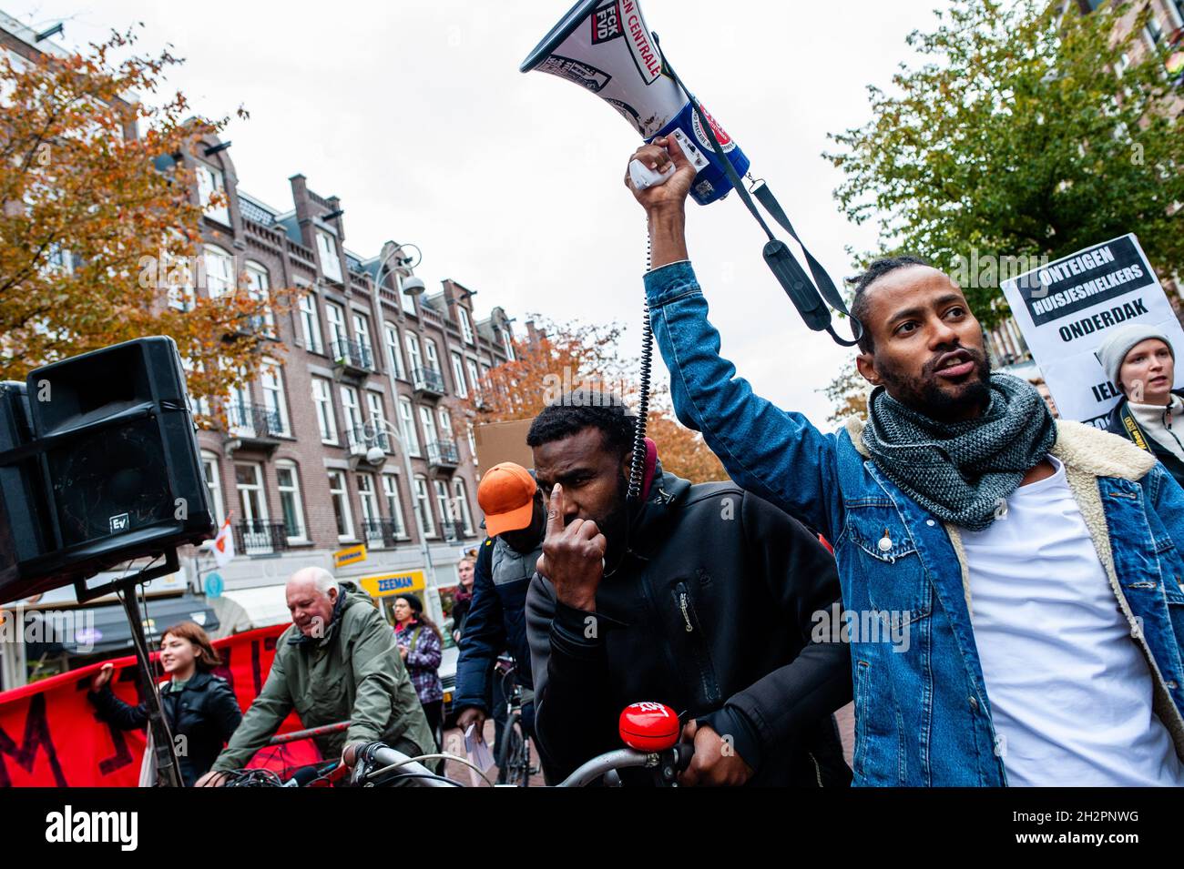 Un homme sans papiers criait des slogans en faveur des réfugiés au cours de la manifestation. « nous sommes ici » est un groupe de personnes sans papiers qui sont à Amsterdam depuis entre 5 et 35 ans.Tous vivent dans l'un des refuges du conseil municipal d'Amsterdam, dans le cadre du projet pilote LVV (Landelijke Vreemdelingen Voorziening) (évaluation des plans et des processus installations nationales pour les étrangers).Parce que ce n'est que temporaire (maximum 1, 5 ans) et que leur temps est à court maintenant, le groupe a organisé une démonstration pour exiger des solutions réelles.La démonstration est passée devant les plusieurs LVV lo Banque D'Images