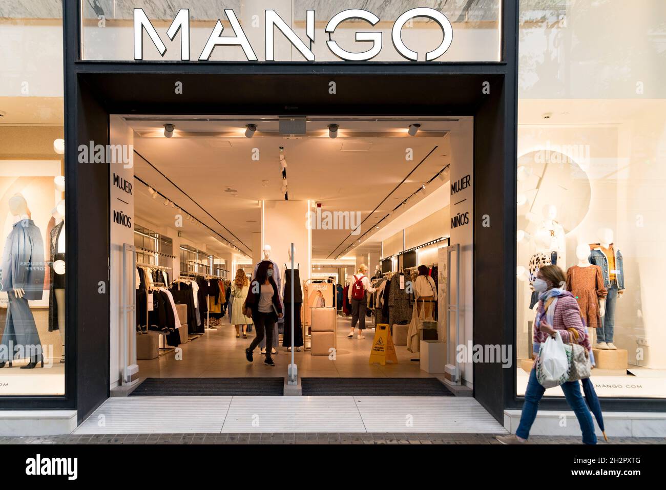 Une femme passe devant le magasin de vêtements Mango à Valence Photo Stock  - Alamy