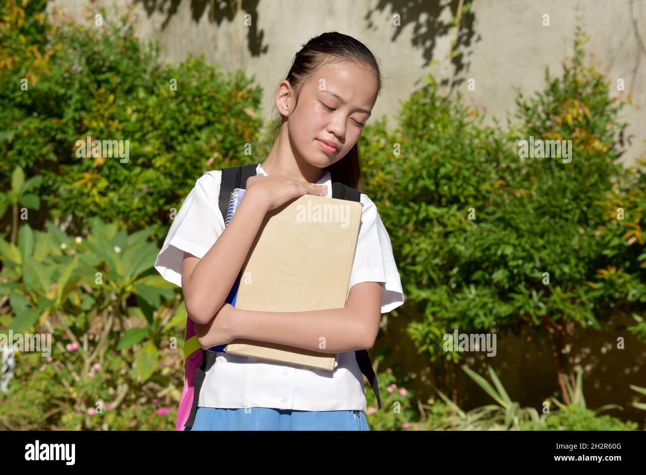 Sleepy belle fille d'école de Filipina avec des cahiers Banque D'Images