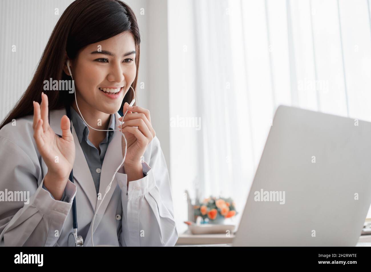 Femme asiatique médecin est en ligne de visite avec un patient sur L'application Internet et l'écoute des symptômes et explique comment traiter le d initial Banque D'Images