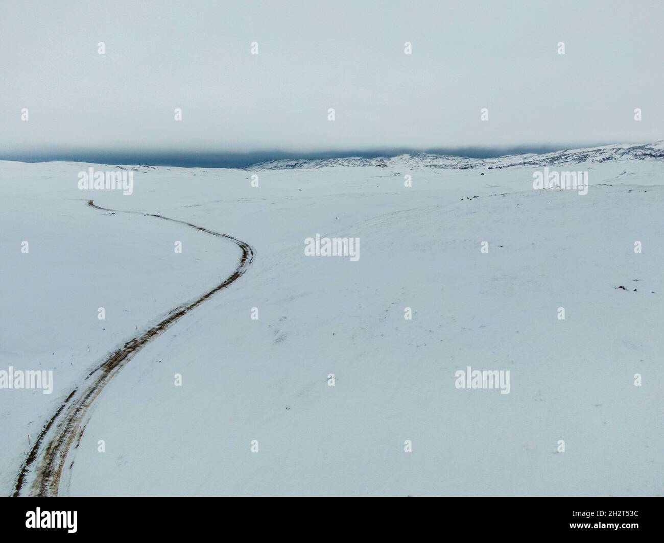 Vue aérienne d'un champ enneigé contre un ciel gris Banque D'Images