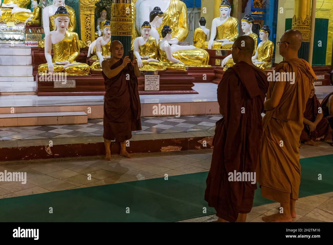 YANGON, MYANMAR - 1er JANVIER 2017 : moine bouddhiste prenant des photos avec un appareil photo pour smartphone le 1er janvier 2017 à la pagode Shwedagon Paya à Yangon, au Myanmar Banque D'Images