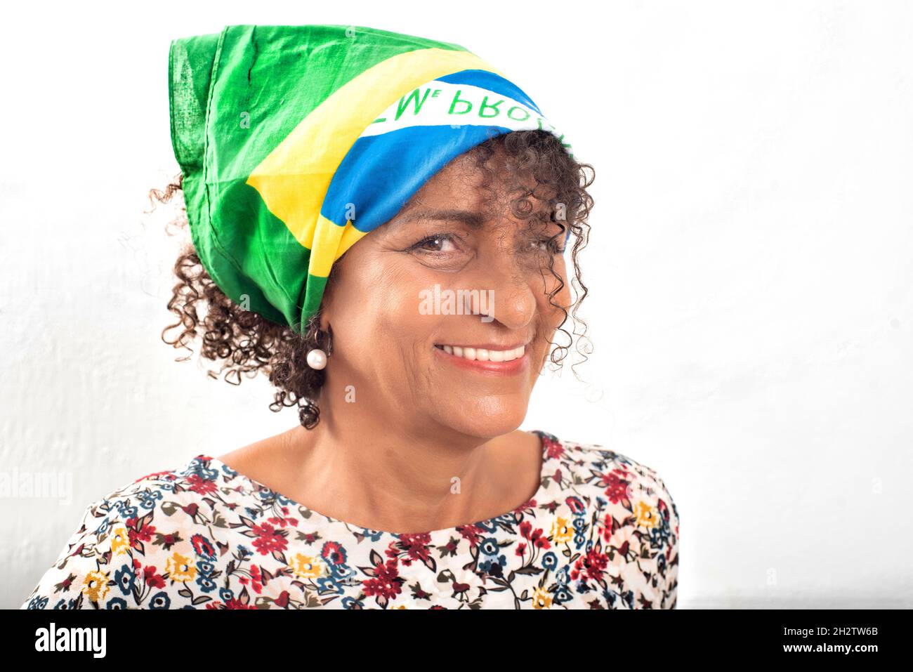Portrait d'une femme brésilienne mûre et souriante portant un bandana avec le drapeau national Banque D'Images