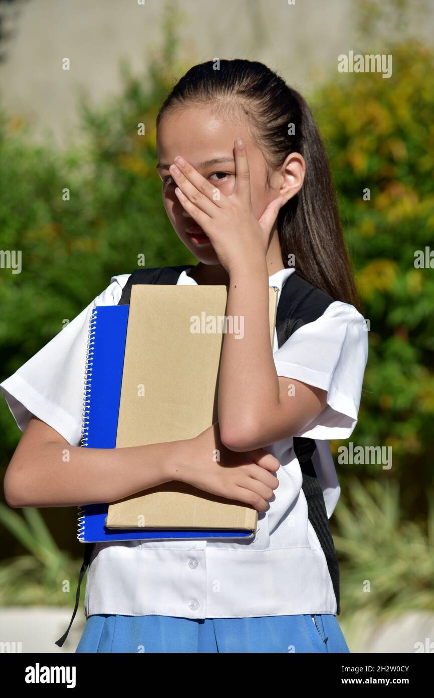 Jeune fille asiatique d'école et de shyness portant uniforme d'école avec des cahiers Banque D'Images
