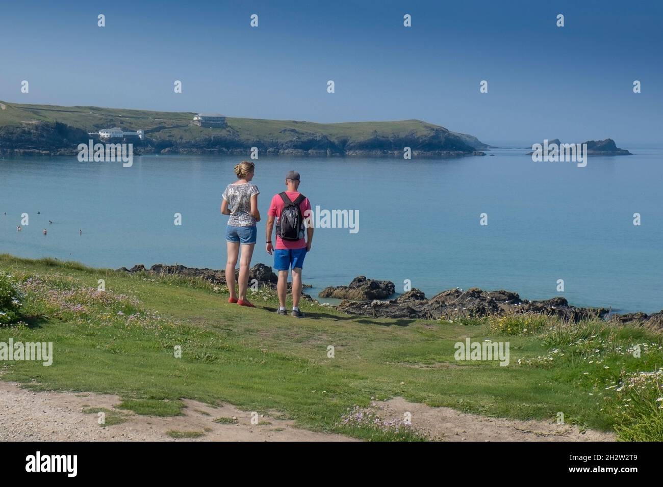 Vacanciers se tenant sur le sentier de la côte et profitant de la vue sur la baie de Fistral à Newquay, dans les Cornouailles. Banque D'Images