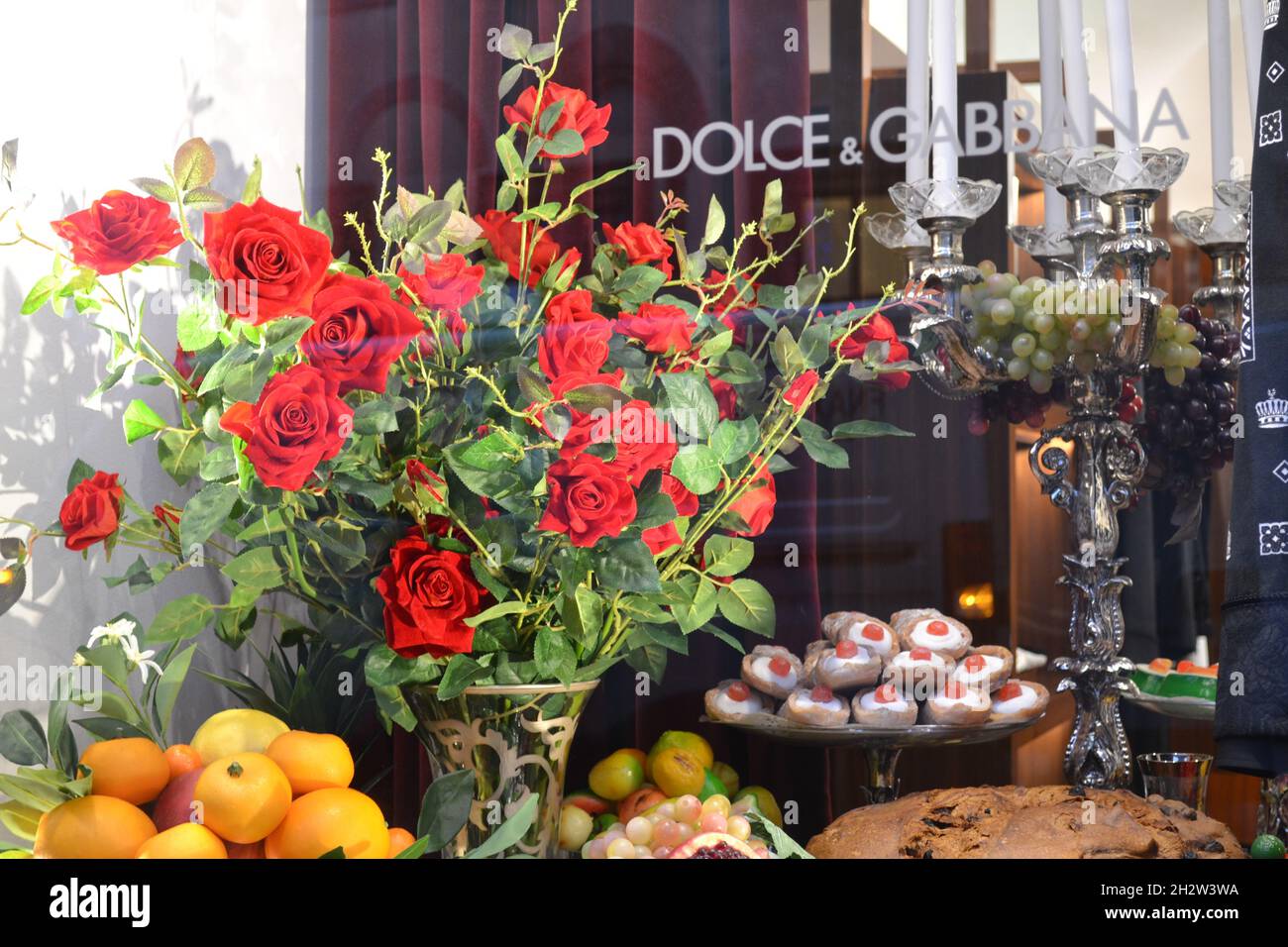 Milan, Italie - 16 décembre 2019 : magnifique vitrine de la Dolce & Gabbana Boutique à Milan avec bouquet de roses rouges, pâtisserie sicilienne. Banque D'Images