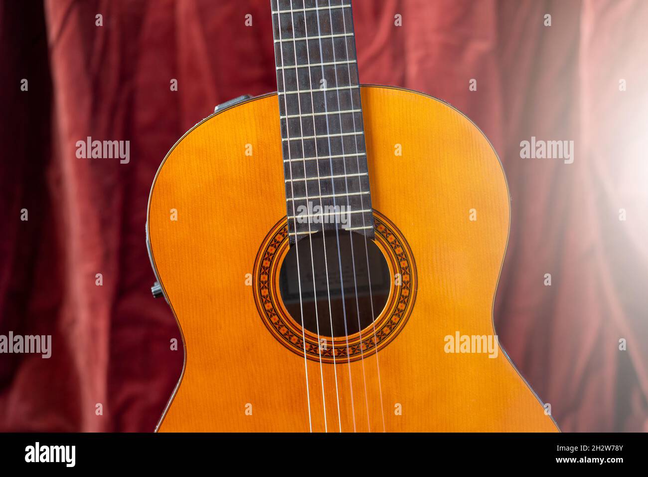 Guitare classique sur fond rouge.Concept de guitare acoustique. Banque D'Images