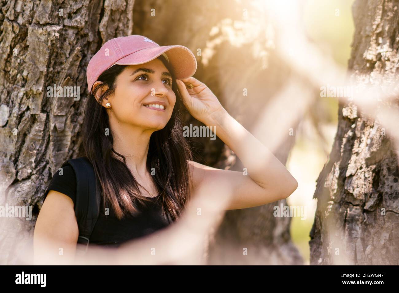 Jeune femme avec chapeau de sport rose souriant dans la nature.Photo de haute qualité Banque D'Images