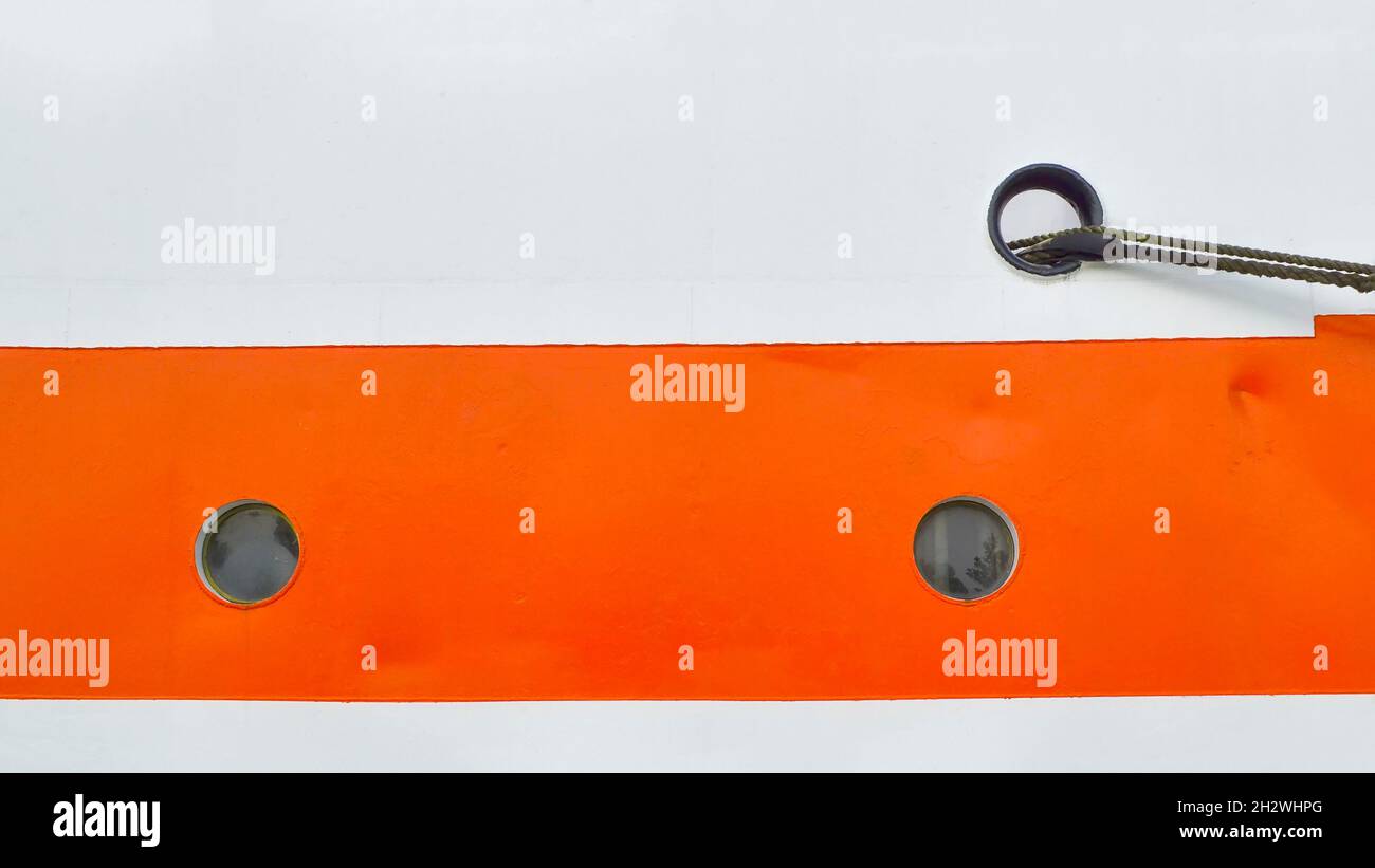 Gros plan de deux petits hublots sur le côté blanc-orange du navire Banque D'Images