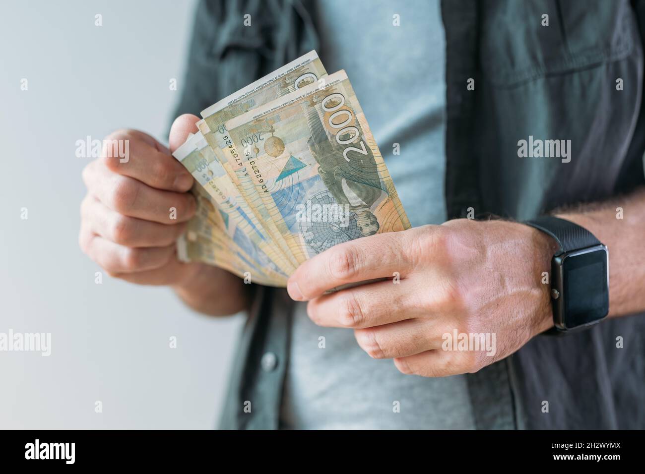 Homme détenant des billets en papier Dinar en monnaie serbe, attention sélective Banque D'Images