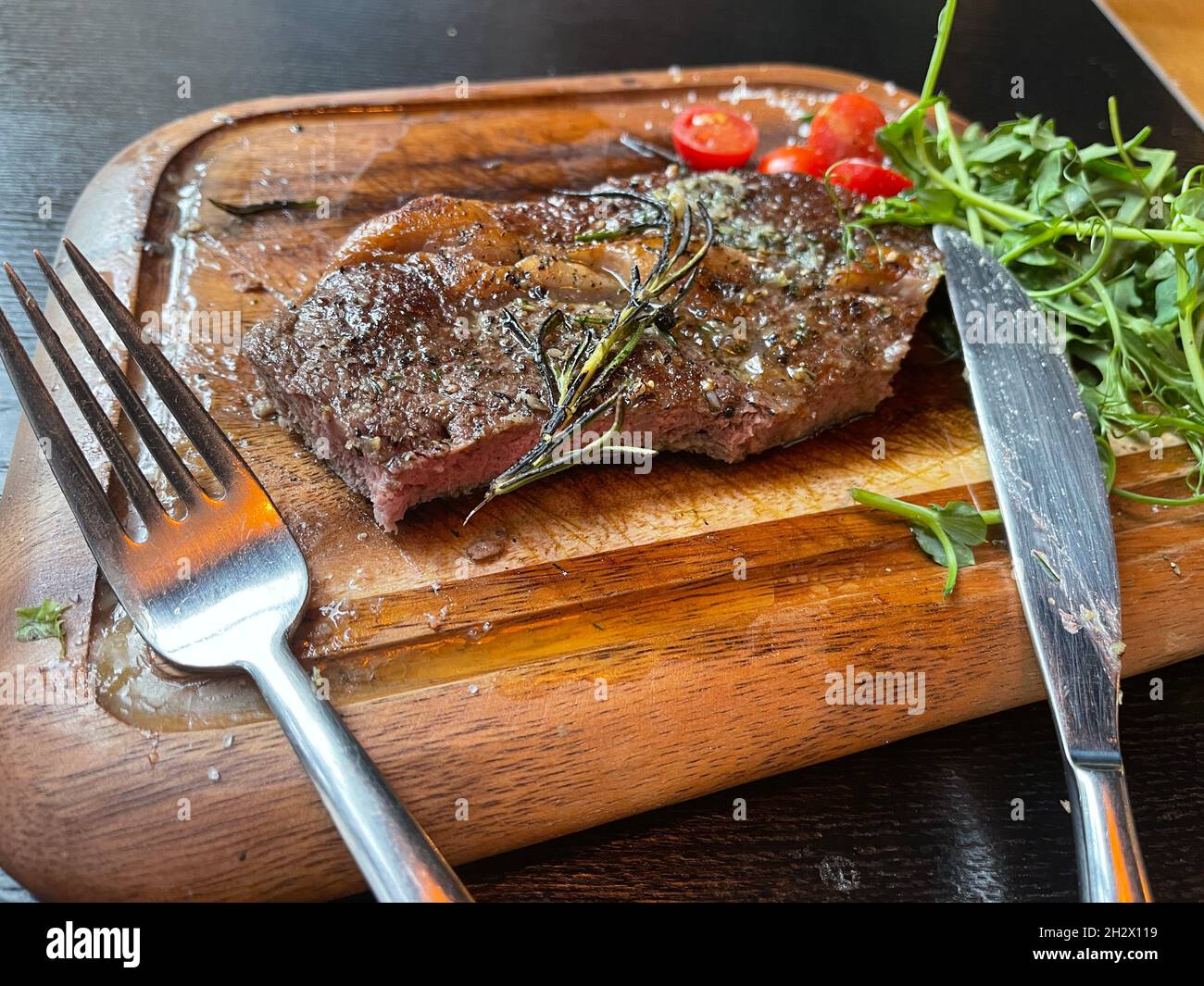 Succulent steak avec des légumes sur une planche de bois.Appétissant viande  assaisonnée sur la planche à découper dans le restaurant Photo Stock - Alamy