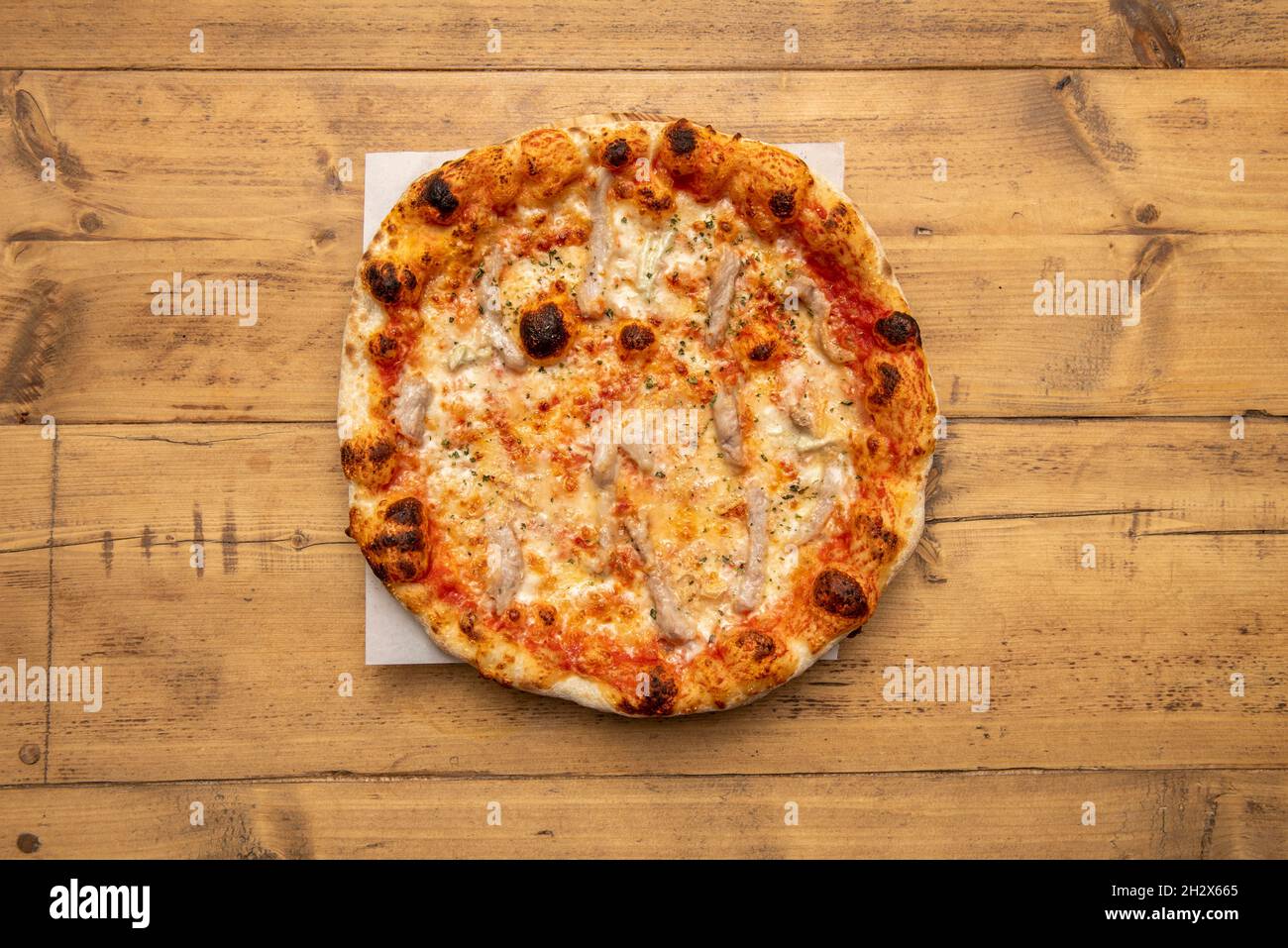 Pizza délicieuse avec recette secrète ibérique avec fromage mozzarella fondu, persil haché sur une table en bois Banque D'Images