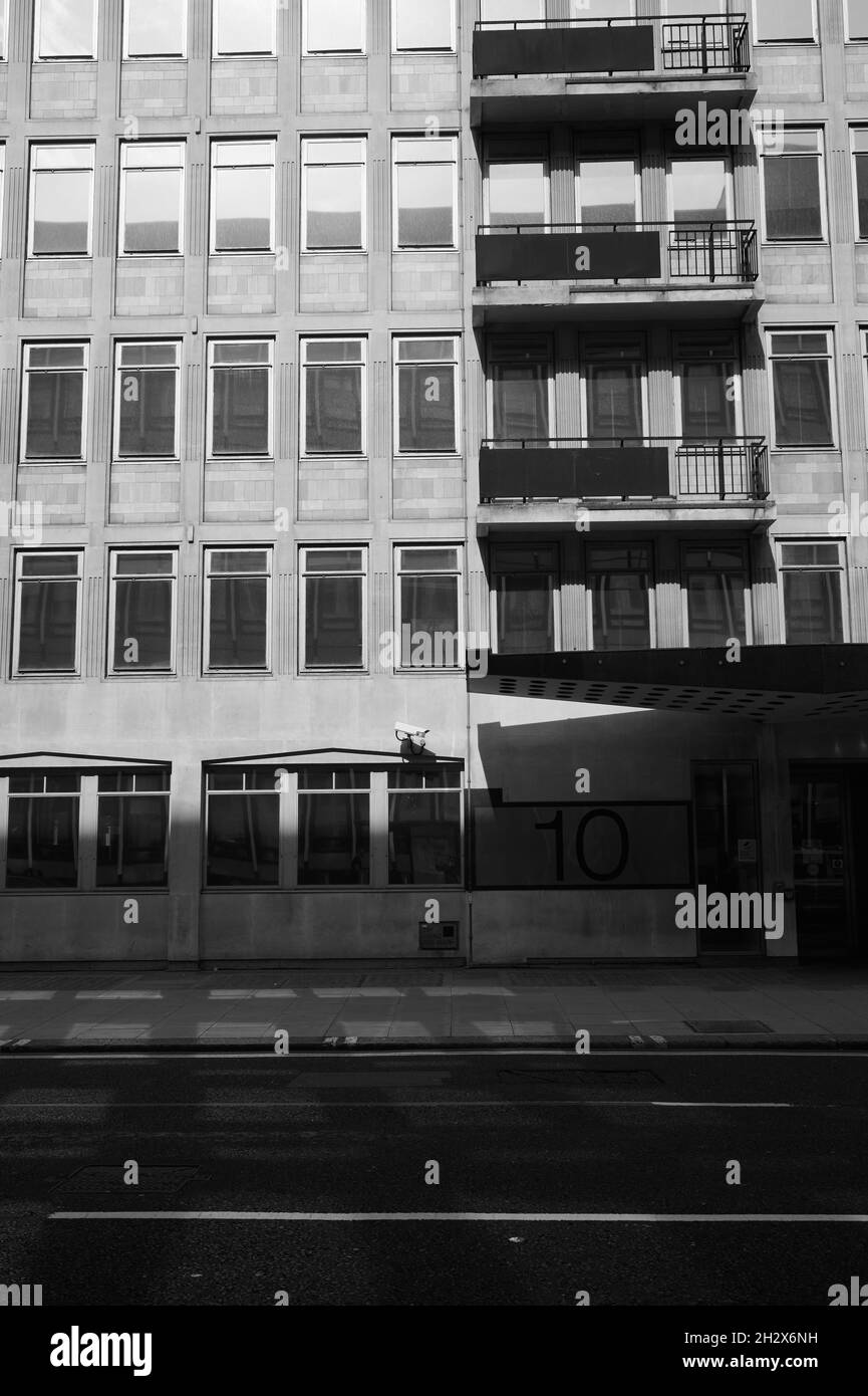 12 septembre 2021 - londres/royaume-uni : image monochrome en noir et blanc de la façade d'un immeuble de bureaux des années 1980 avec balcons sur une rue vide dans une ombre à fort contraste Banque D'Images