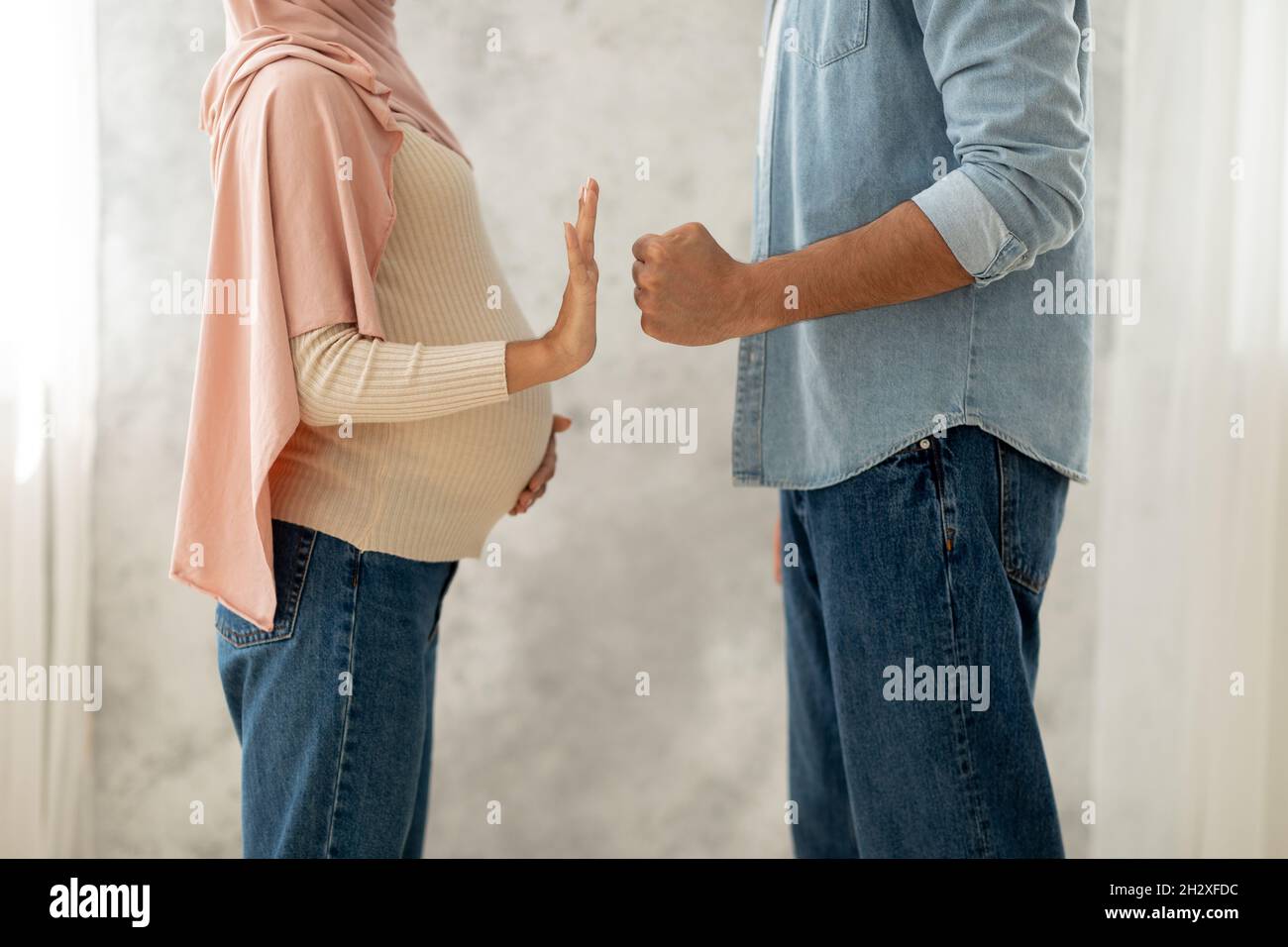 Notion de violence domestique.Mari musulman menaçant femme enceinte de poing, femme montrant un geste d'arrêt Banque D'Images