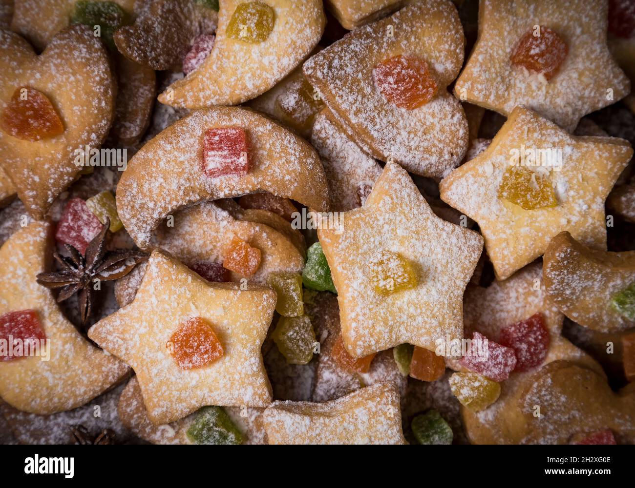 Fond de biscuits au sucre faits maison en coeur, lune, étoiles décorées de fruits confits, sucre glace et anis étoilé japonais.Repas de Noël fes Banque D'Images