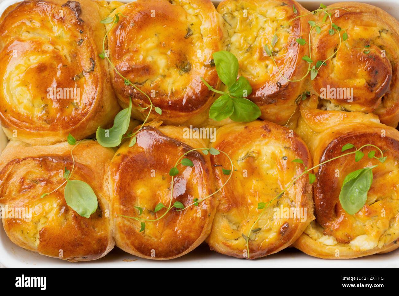 Petits pains au fromage feta et basilic de pâte à levure sur fond de bois clair.Mise au point sélective.Style rustique. Vue sur le dessus. Banque D'Images