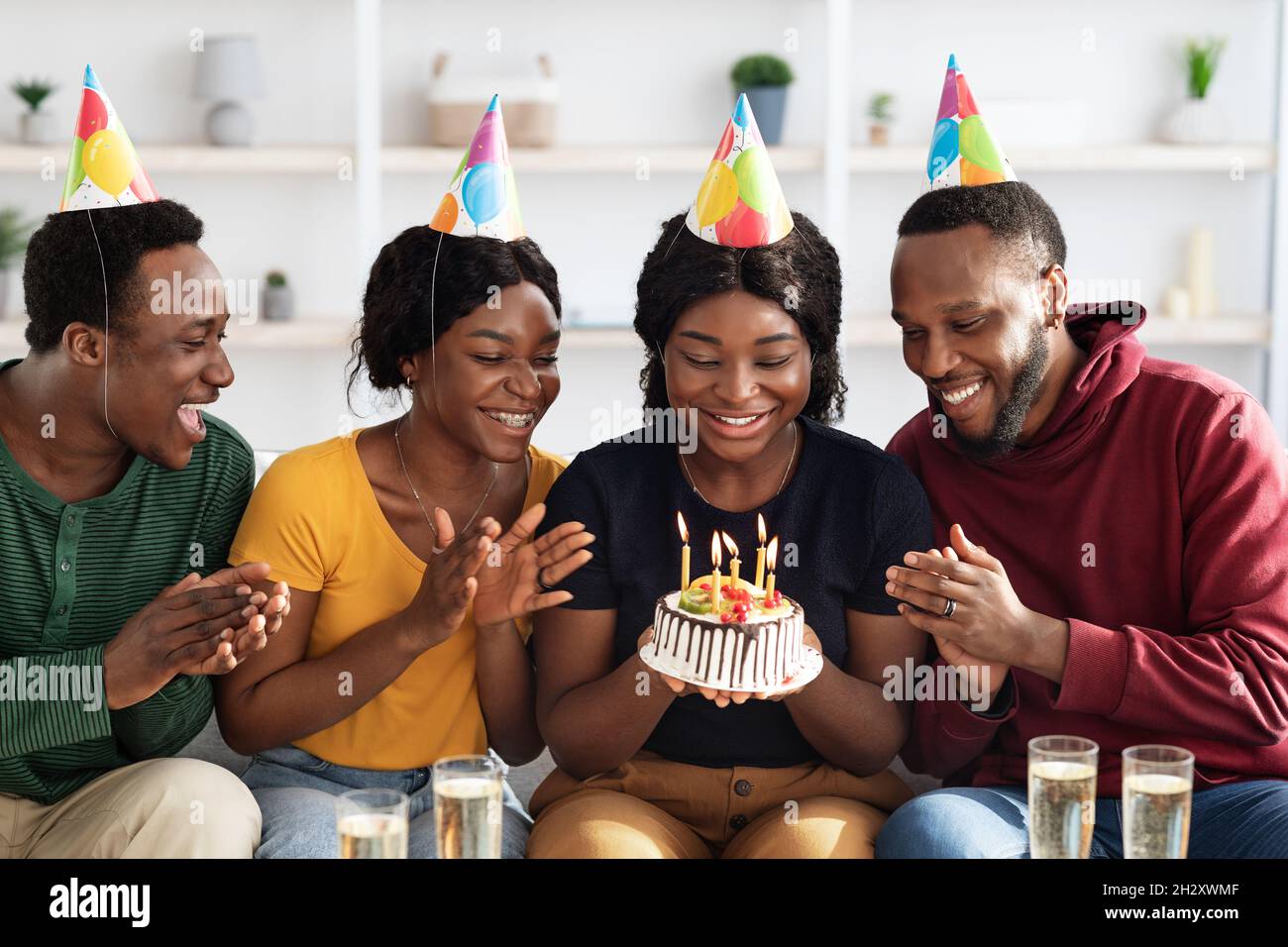 Heureux amis noirs célébrant leur anniversaire à la maison Banque D'Images