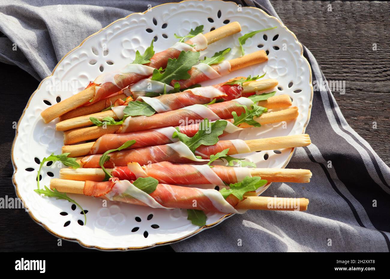 Assiette d'antipasti assiette de viande froide avec bâtonnets de pain de  grissini, prosciutto, tranches de jambon, et arugula sur fond de  bois.Hors-d'œuvre à la viande.Vue de dessus Photo Stock - Alamy