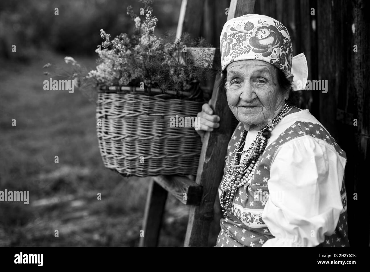 Portrait d'une femme âgée dans des vêtements d'Europe de l'est, à l'extérieur.Photo en noir et blanc. Banque D'Images