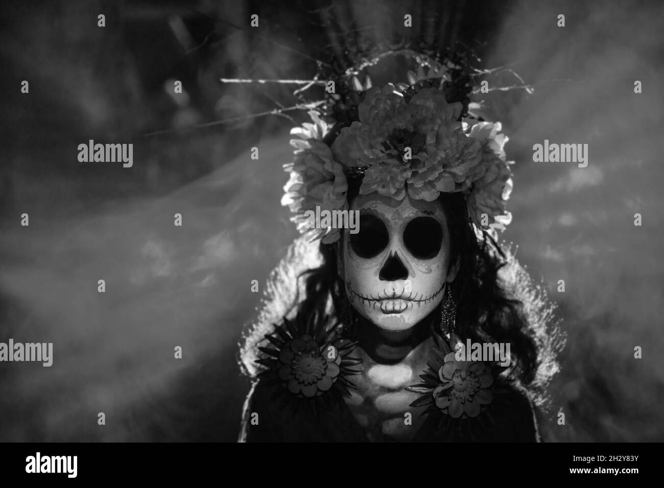 Femme avec calavera mexicain sucre crâne maquillage halloween sur fond sombre. Journée des morts alias Dia de los Muertos et fête traditionnelle d'halloween Banque D'Images