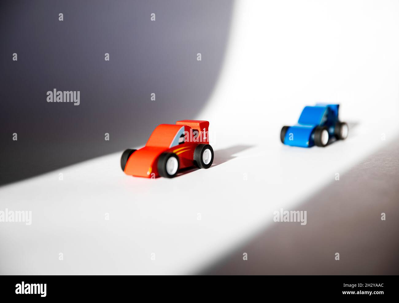 Voitures jouets en bois rouge et bleu avec les numéros 1 et 2. Banque D'Images