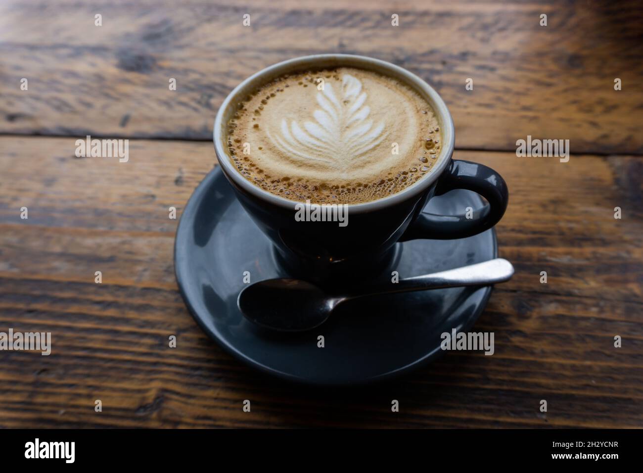 Le Cappucinno est servi sur une table en bois à la cafétéria Banque D'Images