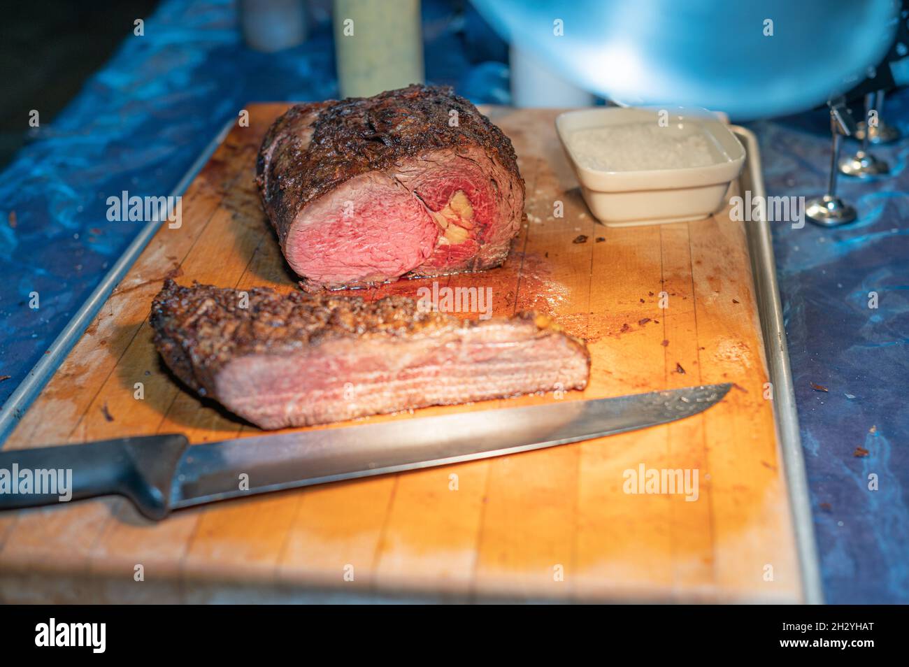 Rôti de bœuf de qualité sur planche à découper en bois avec sel et couteau de cuisine Banque D'Images