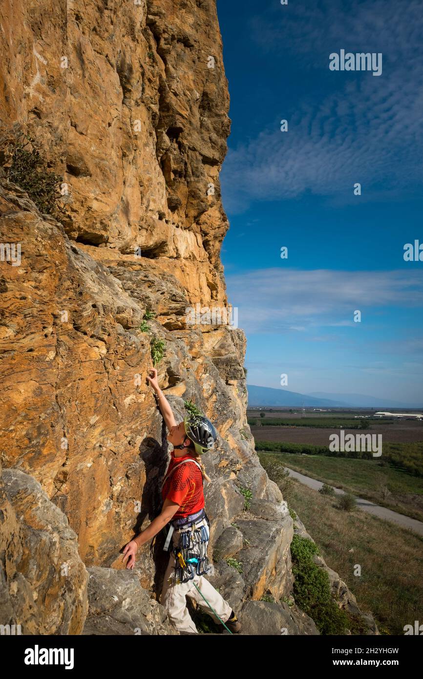 Grimpeur de roche femelle avec clim et plaçant l'équipement de sécurité d'escalade dans le rocher Banque D'Images