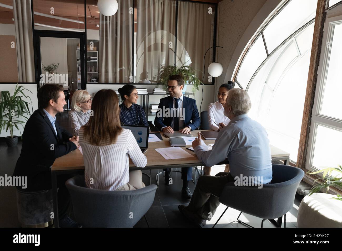 Une équipe d'entreprise amicale composée de divers responsables se réunit pour des séances d'information Banque D'Images