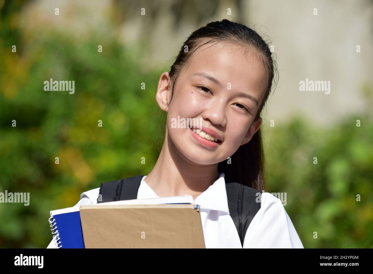 Jeune fille étudiante et bonheur avec des manuels scolaires Banque D'Images