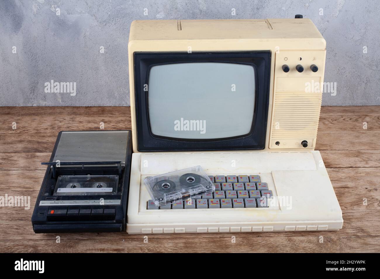 Rétro ordinateur personnel 8 bits avec enregistreur de données et moniteur de télévision sur un bureau en bois Banque D'Images
