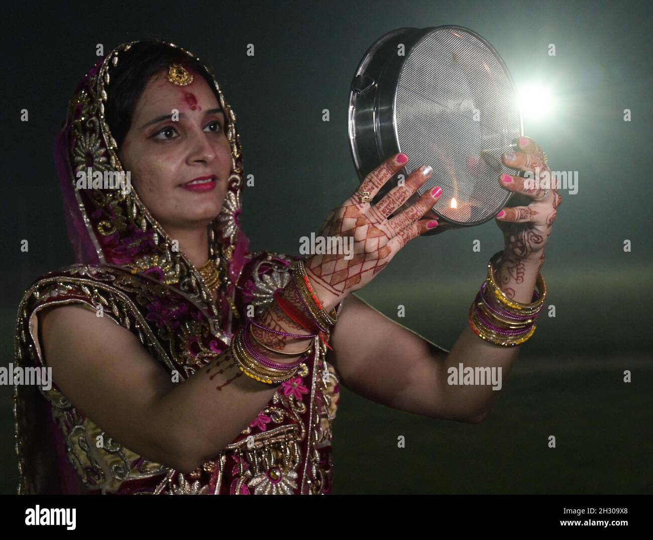 Agartala, État de Tripura, dans le nord-est de l'Inde.24 octobre 2021.Une femme hindoue effectue des rituels lors du festival Karwa Chauth à Agartala, la capitale de l'État indien de Tripura, dans le nord-est de l'Inde, le 24 octobre 2021.Karwa Chauth est un festival hindou traditionnel au cours duquel les femmes mariées jeûnent un jour et offrent des prières à la lune pour le bien-être, la prospérité et la longévité de leurs maris.Credit: STR/Xinhua/Alay Live News Banque D'Images
