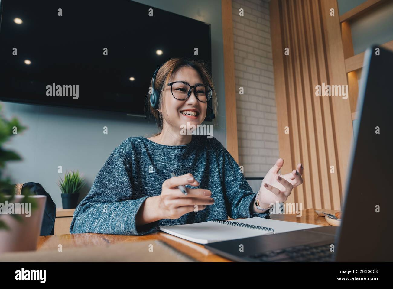 Femme asiatique porter un casque regarder un ordinateur portable étudier en ligne avec un tuteur, écouter une conférence audio regarder un séminaire en ligne se préparer aux examens, e-apprendre, se préparer soi-même Banque D'Images