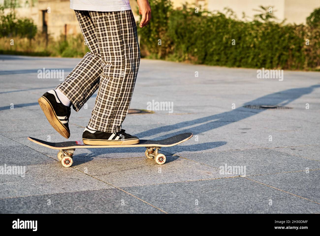 Skateboarder à bord d'une planche à roulettes dans la rue de la ville.  Scrater pratique les tours de skate board au skate Park. Sport extrême  adolescent Photo Stock - Alamy