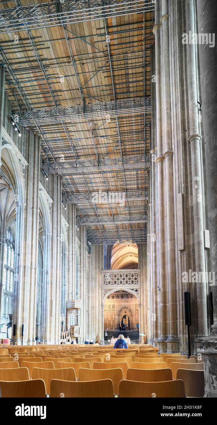 Un visiteur se trouve dans la nef de la cathédrale de Canterbury, en Angleterre, avec un échafaudage sous le toit et à l'extrémité ouest, octobre 2021. Banque D'Images