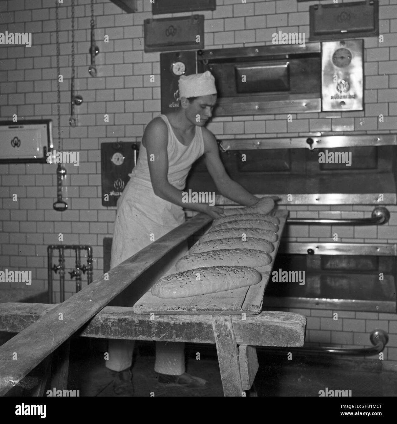 Ein Bäcker BEI seiner täglichen Arbeit, Deutschland 1950er Jahre.Un bakerman et son entreprise quotidienne, l'Allemagne des années 1950. Banque D'Images