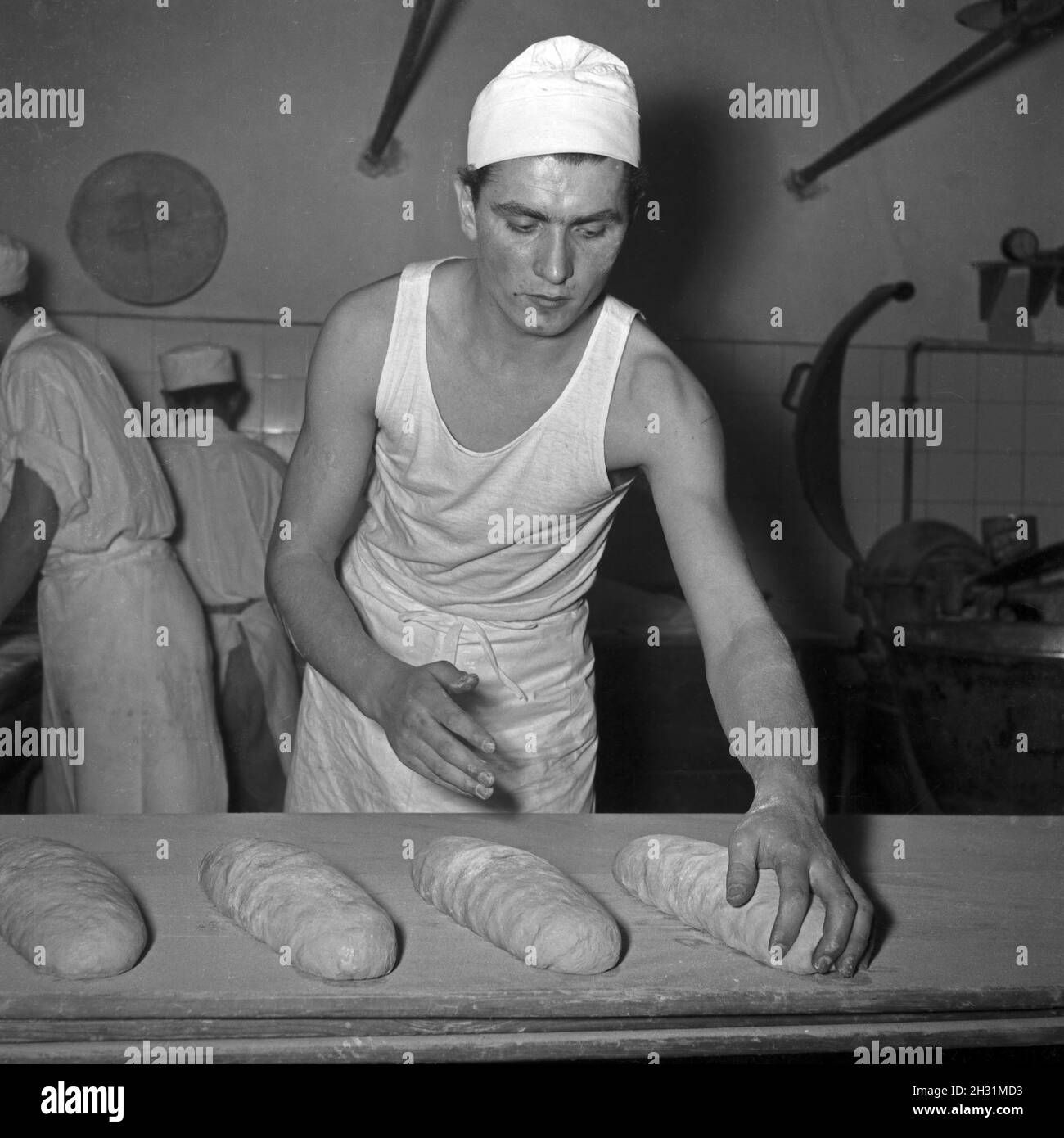 Ein Bäcker BEI seiner täglichen Arbeit, Deutschland 1950er Jahre.Un bakerman et son entreprise quotidienne, l'Allemagne des années 1950. Banque D'Images