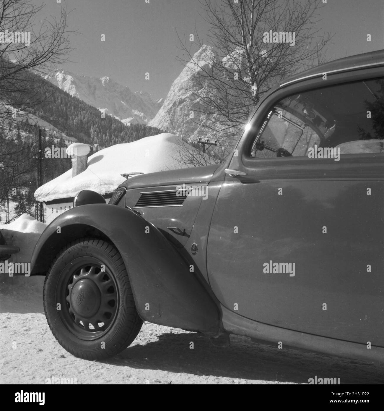 Ford Eifel vor einer Station der Zugspitzbahn, Deutschland 1930er Jahre.Ford modèle Eifel en avant d'une gare du train de montagne Zugspitzbahn, Allemagne des années 1930. Banque D'Images