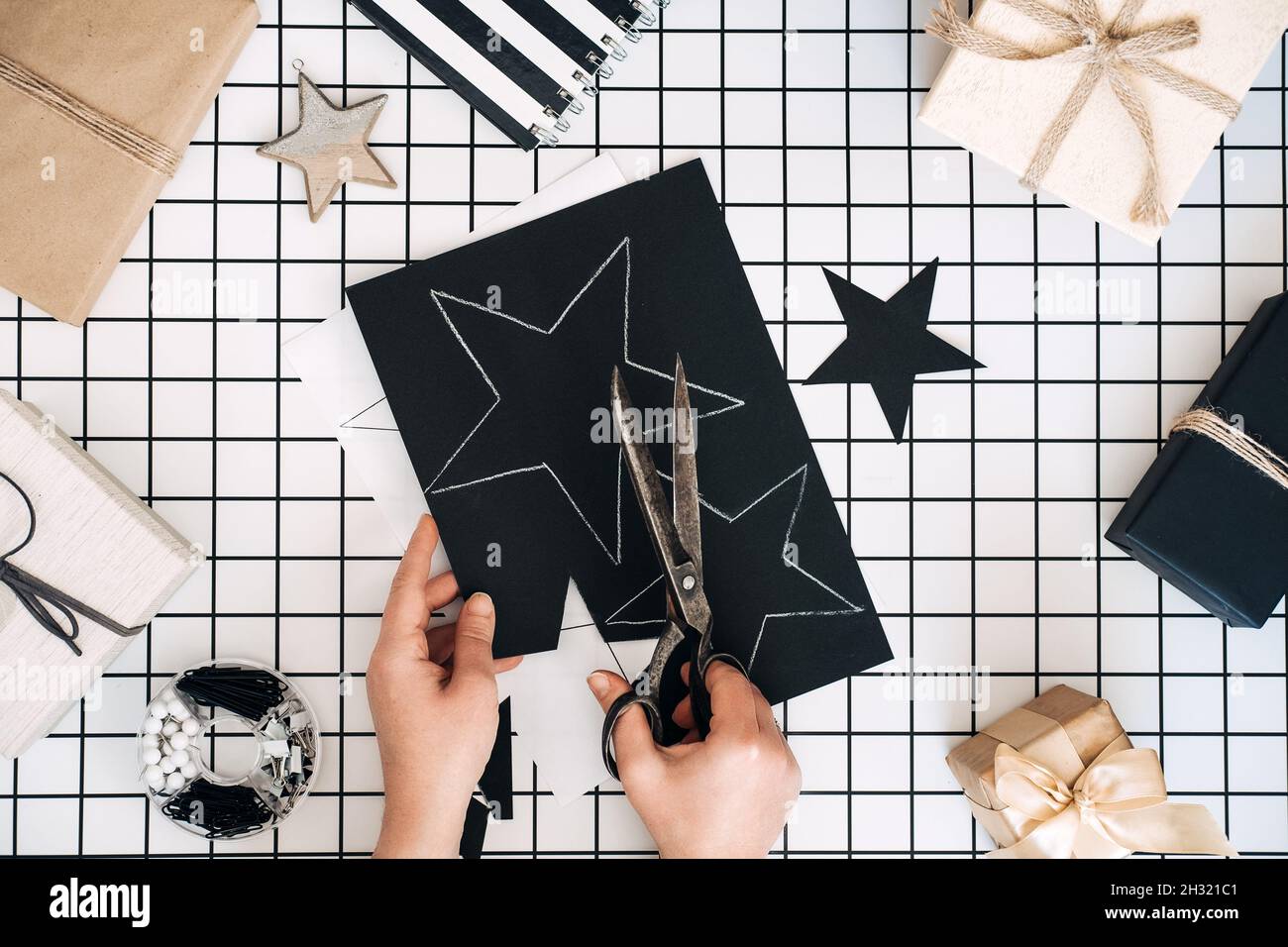 Idées créatives d'emballage de cadeaux.Cadeaux personnalisés.Plat moderne noir et blanc avec processus d'emballage cadeau. Ciseaux, boîtes d'artisanat enveloppées et Banque D'Images