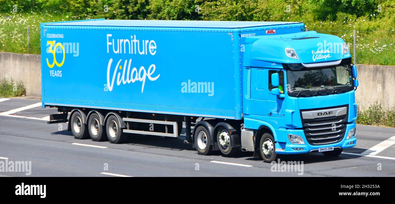 DAF hgv juggernaut camion conducteur et Blue Furniture Village commerce de détail remorque articulée chaîne d'approvisionnement conduite le long de la route d'autoroute britannique Angleterre Banque D'Images