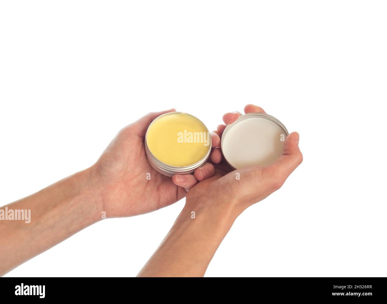 De belles mains de femmes tiennent un pot avec un produit cosmétique.Maquette de crème hydratante, cire, beurre, isolée sur fond blanc.Copier l'espace. Banque D'Images