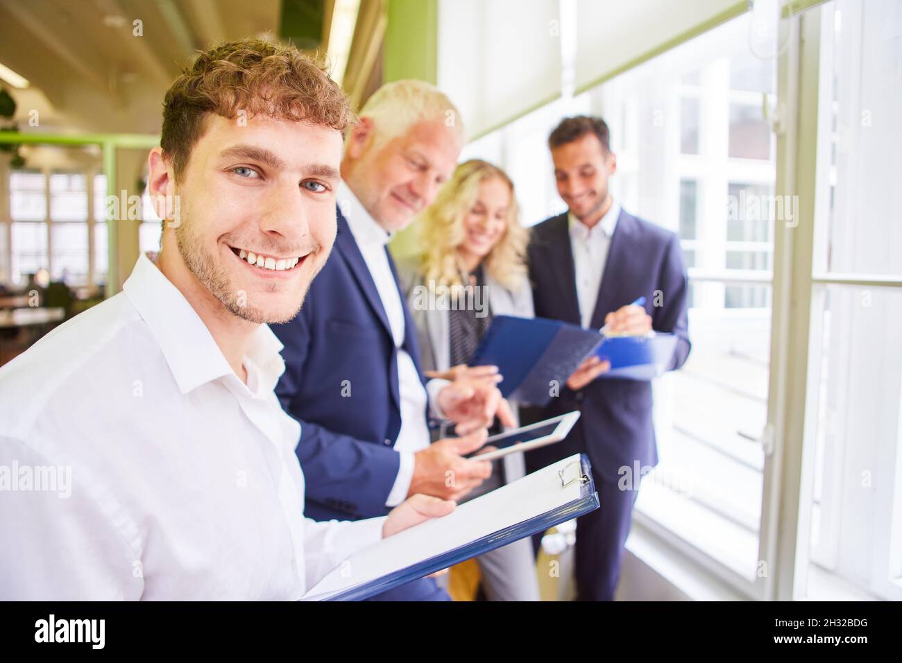Jeune homme d'affaires comme entrepreneur de démarrage avec équipe dans l'atelier de remue-méninges Banque D'Images