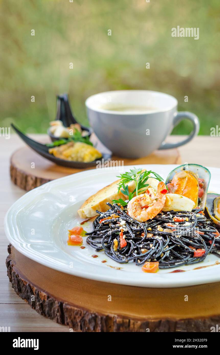 pâtes noires avec fruits de mer sur une assiette blanche Banque D'Images