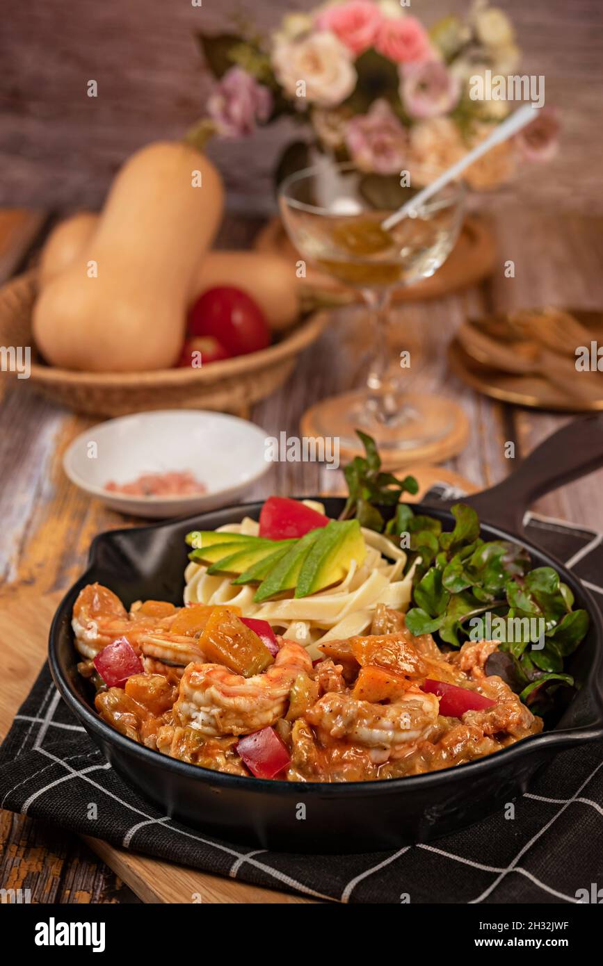 Spaghetti aux crevettes et légumes sur plat blanc, sauce tomate Banque D'Images