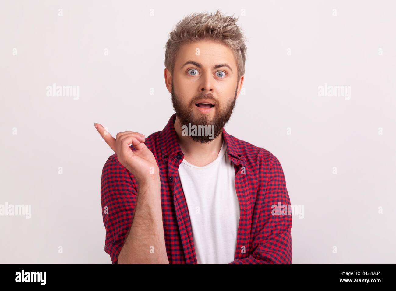 Portrait de l'homme barbu inspiré avec la bouche ouverte pointant le doigt vers le haut et regardant l'appareil photo, ayant une bonne idée, inspiration.Prise de vue en studio isolée sur fond gris Banque D'Images