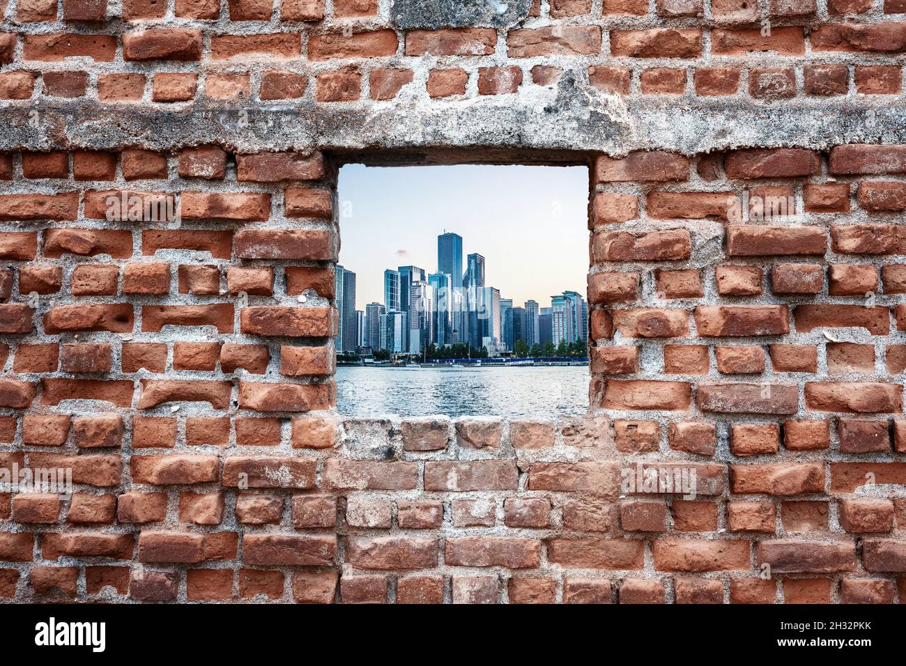 Vieille fenêtre en briques en ruines avec vue sur la mer et les gratte-ciel.Concept d'urbanisation. Banque D'Images