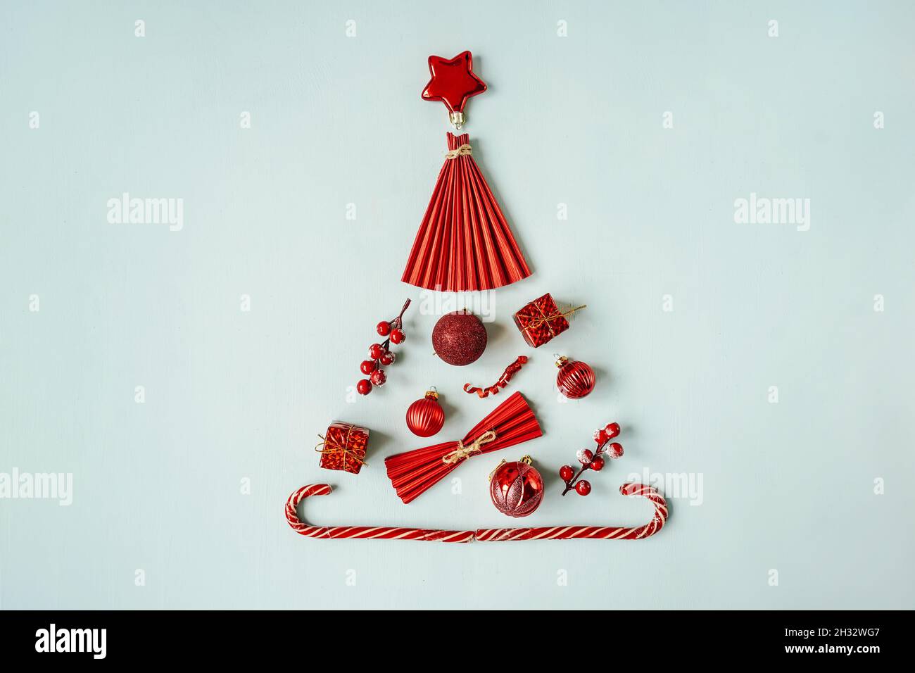 Sapin de Noël en tricot rouge sur fond bleu, plat. Banque D'Images