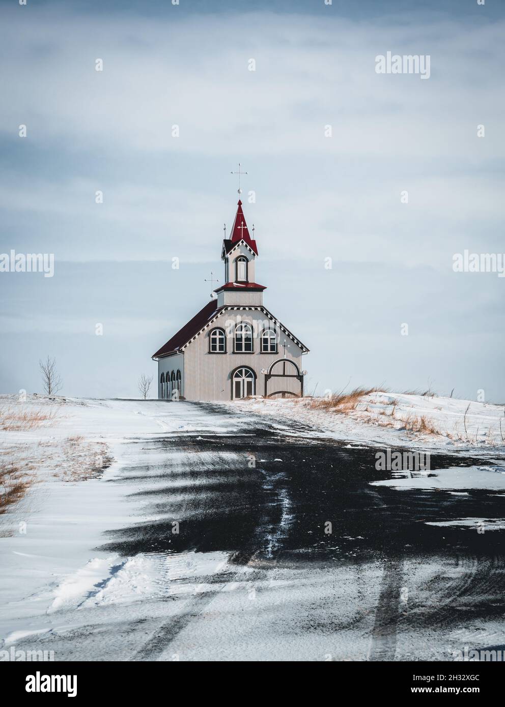 Église islandaise rurale typique sous un ciel bleu nuageux en hiver avec de la neige.Tir horizontal. Banque D'Images